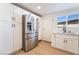 Well-lit kitchen features stainless steel refrigerator, white cabinets and countertops, and a window overlooking outside at 5069 Hallet Dr, Las Vegas, NV 89122