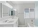 Modern bathroom with dual sinks, a large mirror, and marble-look tiled accents at 5116 Iron Crossing Ave, Las Vegas, NV 89131