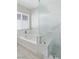 Bathroom featuring a soaking tub with marble-look tile surround and a glass-enclosed shower at 5116 Iron Crossing Ave, Las Vegas, NV 89131