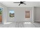 Bright bedroom with wood-look flooring, ceiling fan, and natural light from two windows at 5116 Iron Crossing Ave, Las Vegas, NV 89131