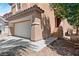 Home featuring a two-car garage, driveway, and desert landscaping at 5116 Iron Crossing Ave, Las Vegas, NV 89131