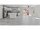 Open-concept living space with gray plank flooring, a kitchen, and a sliding glass door to the back patio at 5116 Iron Crossing Ave, Las Vegas, NV 89131
