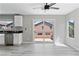 Living room with windows, sliding door, gray plank flooring, and a ceiling fan at 5116 Iron Crossing Ave, Las Vegas, NV 89131