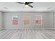 Living room featuring three windows, light gray paint and light gray wood-look flooring at 5116 Iron Crossing Ave, Las Vegas, NV 89131