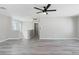 Upstairs landing with gray plank flooring, windows, and a ceiling fan at 5116 Iron Crossing Ave, Las Vegas, NV 89131