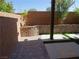 Corner of a backyard with landscaping, brick retaining wall, and pavers at 5889 Thistle Meadow Ave, Las Vegas, NV 89139