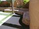 Landscaped backyard featuring modern hardscape and multi-tiered retaining walls with green grass accents at 5889 Thistle Meadow Ave, Las Vegas, NV 89139