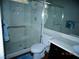 Modern bathroom with marble walled shower, glass door, toilet, and marble countertop with dark cabinets at 5889 Thistle Meadow Ave, Las Vegas, NV 89139