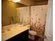 Cozy bathroom with a marble countertop, sink, toilet, and a floral patterned shower curtain at 5889 Thistle Meadow Ave, Las Vegas, NV 89139