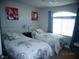 Cozy bedroom featuring two twin beds, bright floral paintings, and a window at 5889 Thistle Meadow Ave, Las Vegas, NV 89139