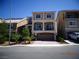 Inviting three-story home boasting a neutral stucco exterior, balcony, and an attached two-car garage at 5889 Thistle Meadow Ave, Las Vegas, NV 89139