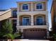 Inviting three-story home boasting a neutral stucco exterior, balcony, and an attached two-car garage at 5889 Thistle Meadow Ave, Las Vegas, NV 89139