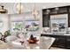 Designer kitchen featuring granite island, dark cabinets, stainless steel appliances and windows overlooking a yard at 5889 Thistle Meadow Ave, Las Vegas, NV 89139