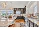 Modern kitchen features dark cabinetry, stainless steel appliances, granite countertops, and wood flooring at 5889 Thistle Meadow Ave, Las Vegas, NV 89139