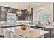 Granite island, stainless appliances, dark cabinets, mosaic backsplash and designer light fixtures create a lovely kitchen at 5889 Thistle Meadow Ave, Las Vegas, NV 89139