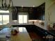 Kitchen with dark wood cabinetry, stainless steel appliances, and a granite-topped kitchen island at 5889 Thistle Meadow Ave, Las Vegas, NV 89139