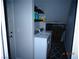 Compact laundry room with white washer and dryer units and wire shelving at 5889 Thistle Meadow Ave, Las Vegas, NV 89139