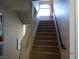 Upward view of a staircase featuring wood railing and natural light from a window above at 5889 Thistle Meadow Ave, Las Vegas, NV 89139