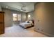 Bright bedroom featuring a ceiling fan, neutral tones, carpet floors, and sliding glass door to a balcony at 6 Yorkridge Ct, Henderson, NV 89052