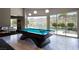 Spacious game room featuring a pool table, modern lighting, and seamless indoor-outdoor flow with beautiful pool views at 6 Yorkridge Ct, Henderson, NV 89052