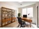 Bright home office with wood desk, shelving, and a comfortable chair offers an ideal workspace at 6387 Azurelyn Ave, Las Vegas, NV 89122