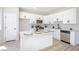 Modern kitchen featuring white cabinets, stainless steel appliances, and a center island with seating at 6387 Azurelyn Ave, Las Vegas, NV 89122