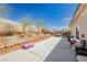 Spacious backyard and patio area with a lush rock garden, mature trees, and plenty of room for outdoor seating at 6688 Martinsville Pl, Las Vegas, NV 89110