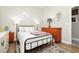 Well-lit bedroom displaying a metal bed frame, dresser, and a cozy rug at 6688 Martinsville Pl, Las Vegas, NV 89110