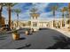 Gated community entrance featuring manicured landscaping, decorative palms, and attractive architecture at 6688 Martinsville Pl, Las Vegas, NV 89110