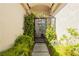 Inviting front entrance with an arched metal gate surrounded by lush greenery, offering a touch of elegance and privacy at 6688 Martinsville Pl, Las Vegas, NV 89110