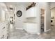 Bright hallway featuring custom cabinetry, tile floors, and convenient access to a nearby powder room at 6688 Martinsville Pl, Las Vegas, NV 89110