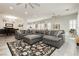 Spacious living room boasting a large gray sectional sofa, stylish rug, and ample natural light, perfect for relaxation at 6688 Martinsville Pl, Las Vegas, NV 89110