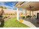 Relaxing covered patio with ceiling fans, artificial turf and desert landscaping providing a serene outdoor living space at 6688 Martinsville Pl, Las Vegas, NV 89110