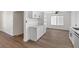 Bright white kitchen with wood-look flooring open to a dining area with lots of natural light at 704 Slayton Dr, Las Vegas, NV 89107