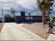 Unique single story house with detached garage, concrete driveway, xeriscaping, and a palm tree at 709 Evergreen Cir, Las Vegas, NV 89107