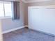 Bright bedroom featuring a large window with curtains and a modern white closet against a neutral wall at 7607 Boca Raton Dr, Las Vegas, NV 89113