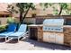 Well-equipped outdoor kitchen with stainless steel grill, side burner, and convenient storage options at 7607 Boca Raton Dr, Las Vegas, NV 89113