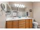 Bathroom featuring double sinks, a large mirror, and an adjacent toilet at 7669 Fieldfare Dr, North Las Vegas, NV 89084