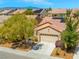 Charming single-story home with a well-manicured lawn, mature trees, and a two-car garage at 7669 Fieldfare Dr, North Las Vegas, NV 89084