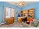 Cozy home office with wooden desk and shelves, complemented by natural light streaming through the window at 7669 Fieldfare Dr, North Las Vegas, NV 89084