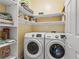 Functional laundry room with washer, dryer, and built-in shelving for ample storage at 7669 Fieldfare Dr, North Las Vegas, NV 89084