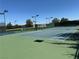 Well-maintained community tennis court, with green and blue playing surface and lighting for evening games at 7669 Fieldfare Dr, North Las Vegas, NV 89084