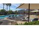 Community pool with lounge chairs, umbrellas, and swaying palm trees at 7704 Classy Cashmere Ct, Las Vegas, NV 89149