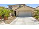 Inviting home exterior featuring a spacious two-car garage and desert landscaping at 7724 Somerhill Point Way, Las Vegas, NV 89139