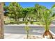 Well-maintained front yard with lush landscaping, mature trees, and a serene neighborhood park at 7724 Somerhill Point Way, Las Vegas, NV 89139