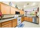 Bright kitchen featuring wood cabinets, granite countertops, and modern appliances at 7724 Somerhill Point Way, Las Vegas, NV 89139