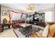 Cozy living room features elegant furniture, decor, large window with draped curtains, and ceiling fan at 7724 Somerhill Point Way, Las Vegas, NV 89139