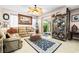 Comfortable living room featuring a leather sofa, ottoman, stylish rug, and decorative cabinet at 7724 Somerhill Point Way, Las Vegas, NV 89139