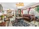 Open-concept living room with luxurious seating, ornate decor, ceiling fan, and stylish rug at 7724 Somerhill Point Way, Las Vegas, NV 89139