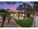 Charming backyard featuring covered patio, landscaped yard, and lush artificial turf at 9029 Rivers Edge Dr, Las Vegas, NV 89117